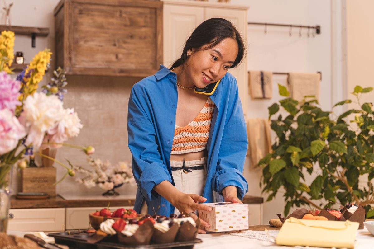 A baker on the phone while packing an order